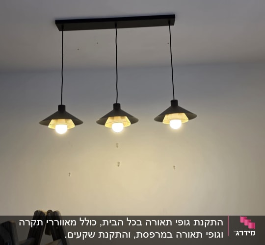 שלושה גופי תאורה תלויים מהתקרה עם סולם